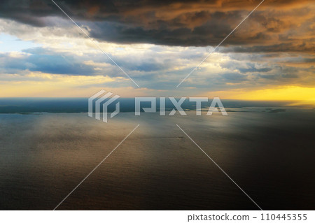 Morning sunrise with Wing of an airplane flying above the ocean. Morning sunrise with Wing of an airplane flying above the ocean. 110445355