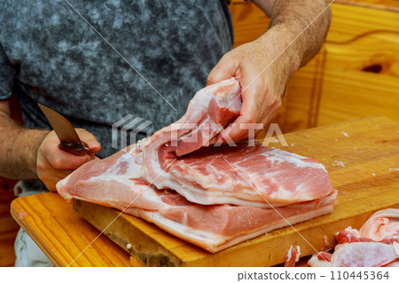 Midsection of butcher cutting meat with cleaver in shop Midsection of butcher cutting meat with cleaver in shop 110445364