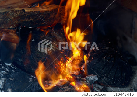 crest of flame on burning wood in fireplace crest of flame on burning wood in fireplace 110445419