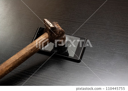 Phone under hammer isolated on wooden table Phone under hammer isolated on wooden table 110445755