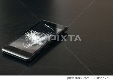 Broken display phone on a wooden table Broken display phone on a wooden table 110445760
