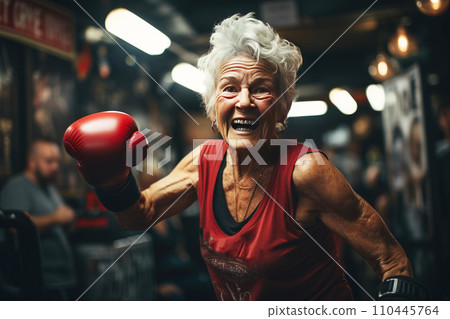 Mature elderly woman pensioner smiling happily doing boxing lifestyle for health in gym. Mature elderly woman pensioner smiling happily doing boxing lifestyle for health in gym. 110445764