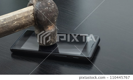 Phone under hammer isolated on wooden table Phone under hammer isolated on wooden table 110445767