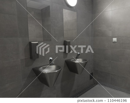 Modern stainless steel public toilet interior in the car park. Hand wash area with gray color ceramic tiles. Stainless washbasins 110446196