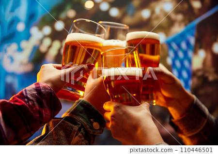 Group of soccer fans sitting in bar and celebrating start of football season. Friends watching match and clinking glasses of beer. Group of soccer fans sitting in bar and celebrating start of football season. Friends watching match and clinking glasses of beer. 110446501