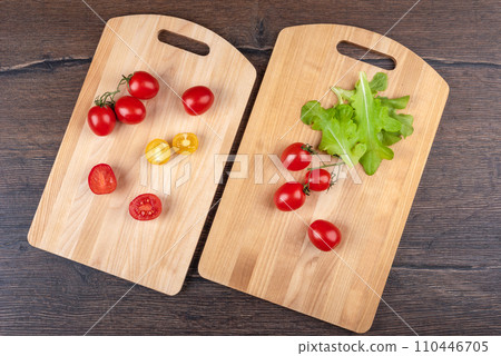 Sliced and whole tomatoes on two cutting boards over a wooden background. Sliced and whole tomatoes on two cutting boards over a wooden background. 110446705