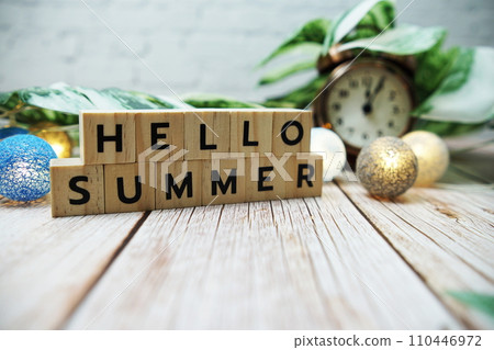 Hello Summer alphabet letter with alarm clock and Monstera leave decoration on wooden background 110446972