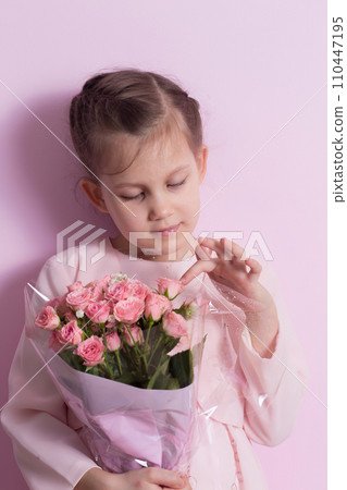 A cute little girl in a pink dress holds a bouquet of pink roses A cute little girl in a pink dress holds a bouquet of pink roses 110447195