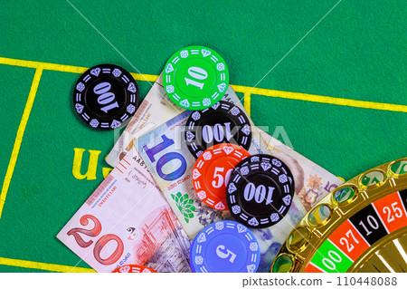 On green gaming table are roulette Georgian banknotes lari poker chips. On green gaming table are roulette Georgian banknotes lari poker chips. 110448088