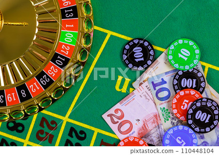 Casino roulette is on green gaming table with Georgian banknotes lari, poker chips. Casino roulette is on green gaming table with Georgian banknotes lari, poker chips. 110448104