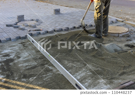 During leveling sand decorative stone for footpath is laid on leveled sand 110448237
