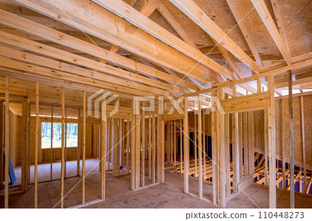 Framing of new unfinished residential home under construction is made up wood supports beam 110448273