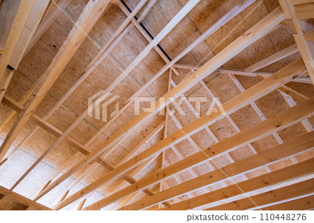 Framing for new residential home under construction in which wooden beam supports Framing for new residential home under construction in which wooden beam supports 110448276