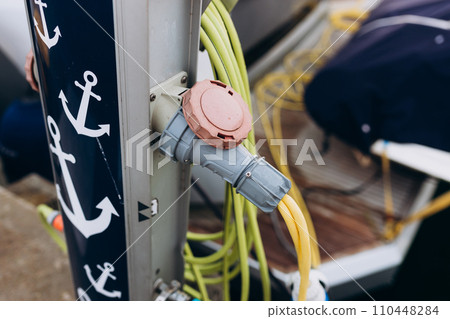 Electrical outlets to charge ships in harbor. Electrical power sockets bollard on pier near sea coast. Marina power pedestal 110448284