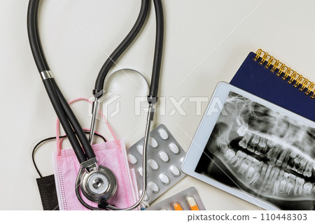 An dental X-ray teeth of patient jaw is viewed on digital tablet by dentist prior to treatment 110448303