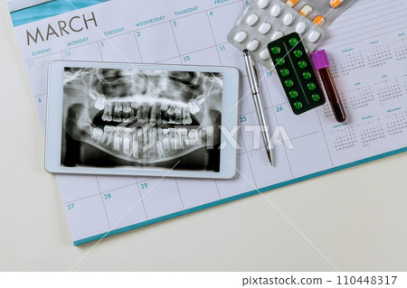 Before treatment, dentist examines an X-ray of the patient jaw on digital tablet Before treatment, dentist examines an X-ray of the patient jaw on digital tablet 110448317