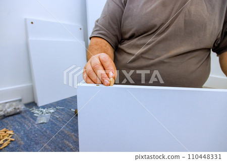 Carpenter is to assemble furniture closet cabinet for room 110448331