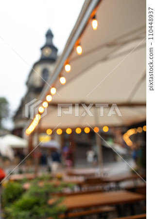 Warm festive bokeh of string lights over an outdoor bar and restaurant patio  110448937