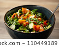 In fresh delicious salad vegetables Close-up stirring with spoon 110449189