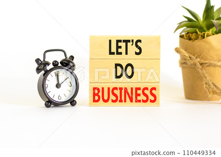 let is do business symbol. Concept words let is do business on beautiful wooden blocks. Beautiful white table white background. Black alarm clock. let is do business concept. Copy space. 110449334