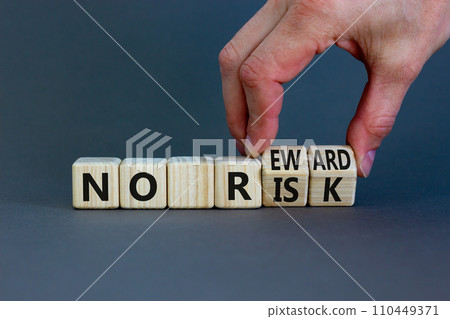 No risk and reward symbol. Businessman turns wooden cubes and changes words 'no risk' to 'no reward'. Beautiful grey background. No risk and reward, business concept. Copy space. 110449371