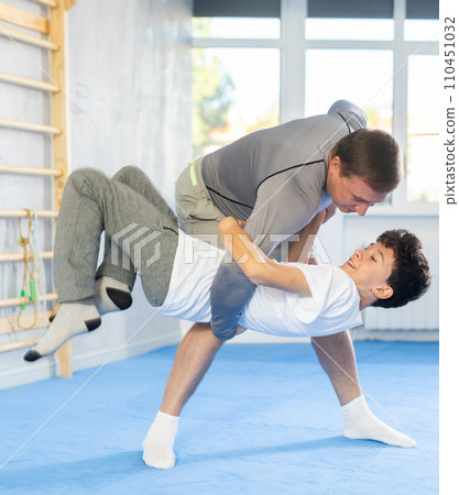 Man and boy teenager training self-defense techniques 110451032