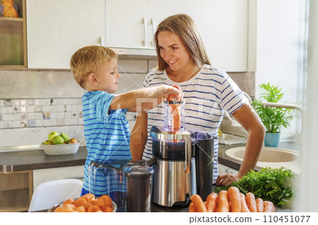 Mother Teaching Son to Use Juicer with Carrots Mother Teaching Son to Use Juicer with Carrots 110451077