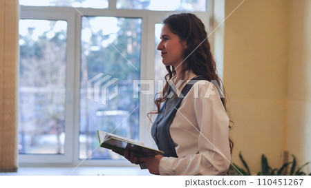 A young female student leads the class in the role of teacher. 110451267