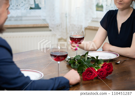 A man and a woman drink red wine after dinner. 110451287