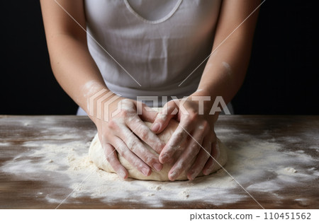 Female hands making dough. Hands kneading bread dough on a cutting board. 110451562