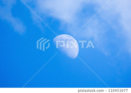 Moon is in blue cloudy sky on a daytime Moon is in blue cloudy sky on a daytime 110451677