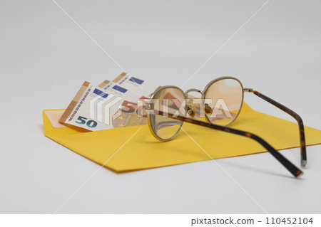 banknotes in a yellow envelope. open envelope with banknotes on a light background. envelope with banknotes. close up of an envelope with cash. international currency banknote. Euro dollars rubles. 110452104