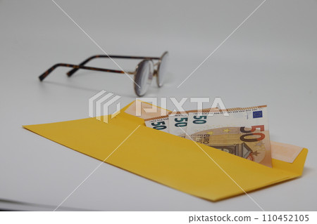 banknotes in a yellow envelope. open envelope with banknotes on a light background. 110452105
