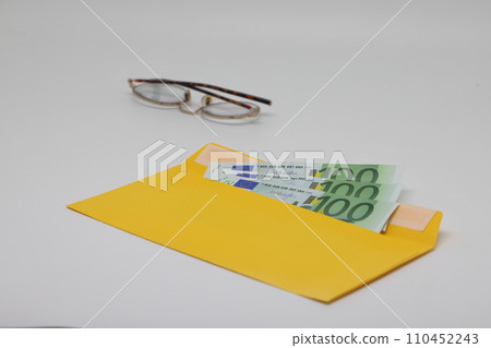 banknotes in a yellow envelope. open envelope with banknotes on a light background. envelope with banknotes. close up of an envelope with cash. international currency banknote. Euro dollars rubles. 110452243