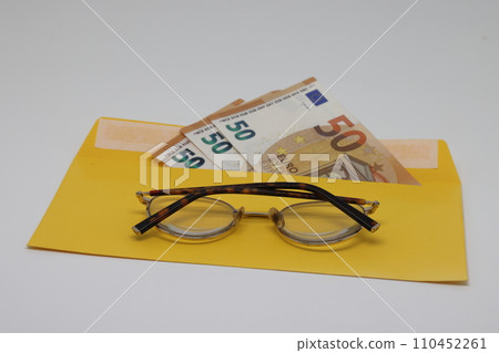 banknotes in a yellow envelope. open envelope with banknotes on a light background. 110452261