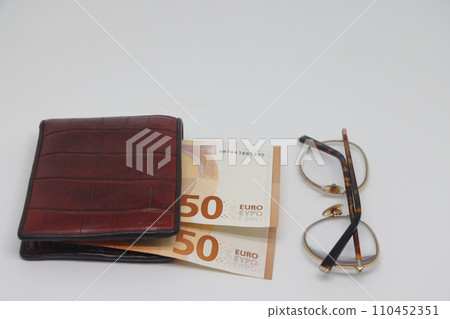 Brown wallet with banknotes and glasses. Brown frame. Symbol of accounting and family finance planning. 110452351
