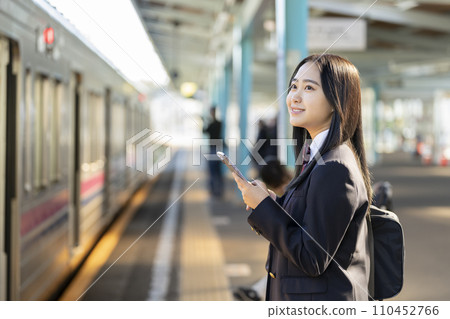 有智慧型手機的高中女孩在月台上等火車 有智慧型手機的高中女孩在月台上等火車 110452766