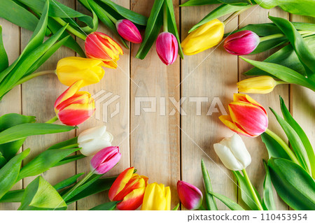Heart of tulip flowers on wooden background. Valentine's day, place for text. Heart of tulip flowers on wooden background. Valentine's day, place for text. 110453954