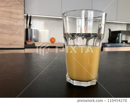 A glass of freshly squeezed orange juice is on the table 110454278
