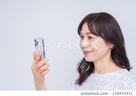 操作智能手機的中年婦女。 操作智能手機的中年婦女。 110455411