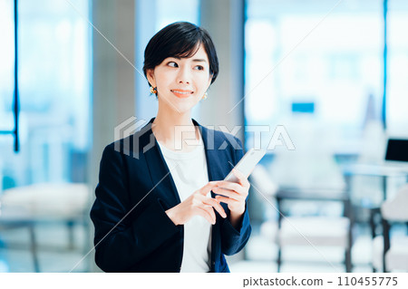A business person operating a smartphone. A business person operating a smartphone. 110455775