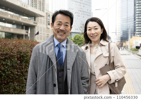 Middle-aged couple smiling with arms crossed 110456330