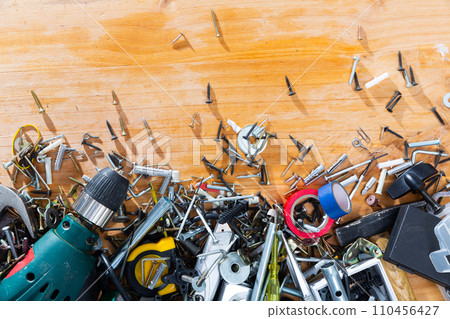 Various screws, bolts, tools on a wooden table. Various screws, bolts, tools on a wooden table. 110456427