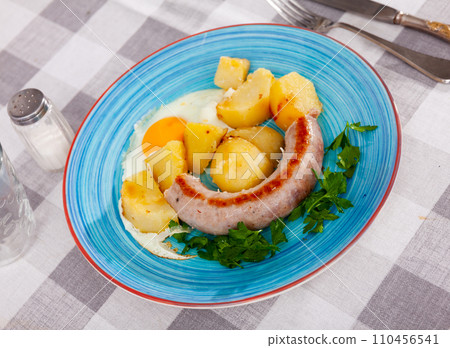 Fried sausages with potato and eggs 110456541