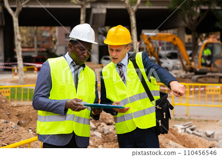 Foreman and engineer check correctness of the pipeline repair on street 110456546