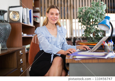 Successful businesswoman working with paperwork and laptop 110456747