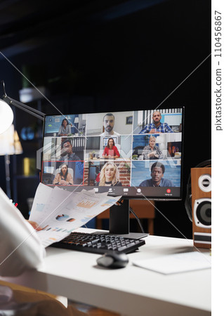 Selective focus on the desktop screen displaying group of people participating in a video conference. Detailed image of professional adults discussing their research in an online meeting. Selective focus on the desktop screen displaying group of people participating in a video conference. Detailed image of professional adults discussing their research in an online meeting. 110456867