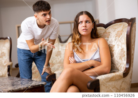 Disgruntled young husband swears at his wife 110456926