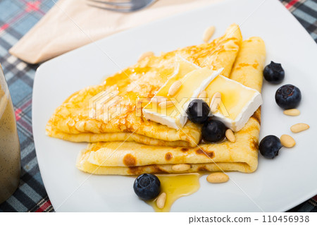 Appetizing pancakes with cheese, honey and nuts 110456938