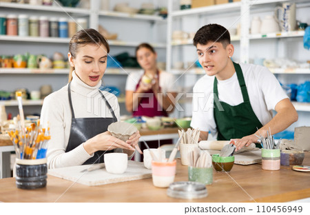 Young woman and young man making pottery 110456949